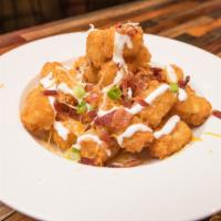 Loaded Tater Tots · Topped with Cheddar Cheese, Bacon Bits, Sour Cream, and Green Onion.