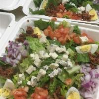 Chopped Cobb Salad · Chopped chicken, bacon, hardboiled eggs, bleu cheese crumbles, red onion and tomatoes on cri...