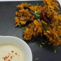 Onion Pakora · Gluten-free, vegan. Crispy onion fritters prepared in South Indian style with curry leaves.