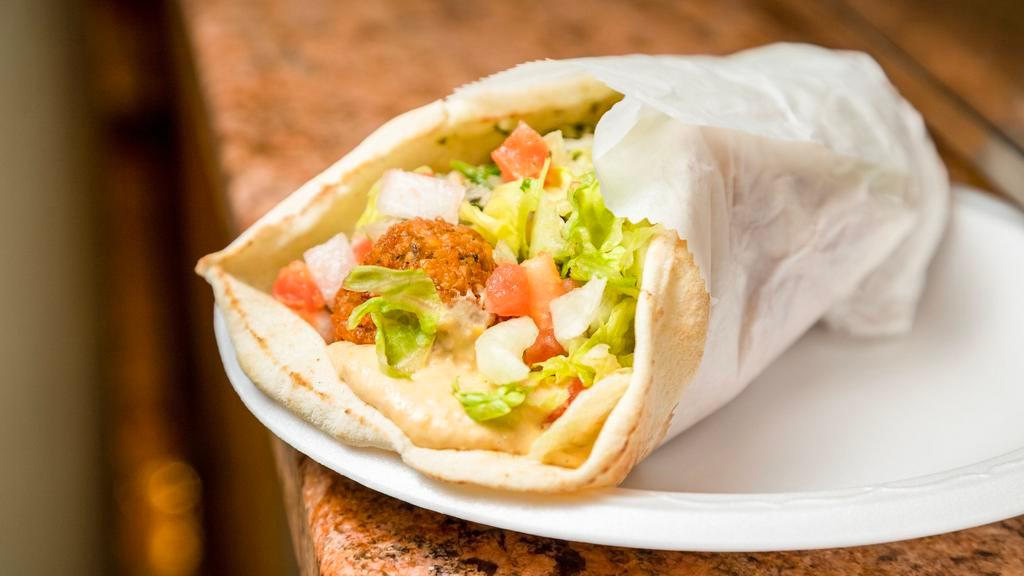 Falafel Wrap · Fried chickpeas with tahini sauce. Served in Greek pita bread with lettuce, tomatoes and onions.