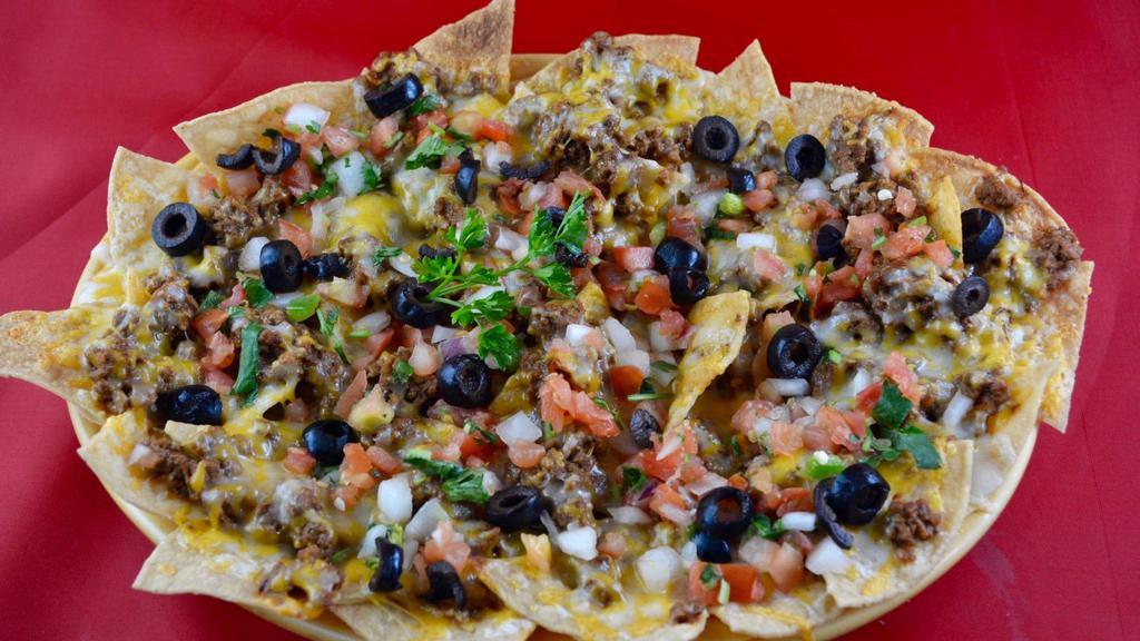 Nachos Con Carne · Tortilla chips covered in cheese, beef, olives, and pico de gallo.