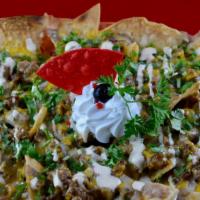 Steak Chipotle Nachos · Grilled steak with onions, beans, sour cream, cilantro, chipotle sauce and melted cheese.