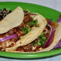 Zamora Tacos · 2 seasoned steak tacos, with grilled mozzarella cheese and onions. Topped with cilantro, bla...