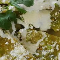 Chilaquiles · Triangle shaped corn tortillas smothered in verde or roja sauce topped with cheese, avocado ...