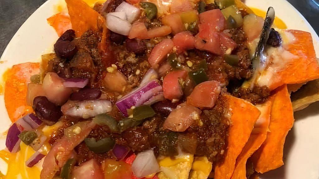 Loaded Nachos · Your choice of homemade chili or buffalo chicken. On tri-colored cooked to order nacho chips topped with jack and cheddar cheese, pico de gallo and sour cream.