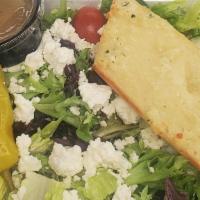 Greek Salad · Mixed greens topped with Feta, tomatoes, cucumber, red onion, black olives, pepperoncini, an...