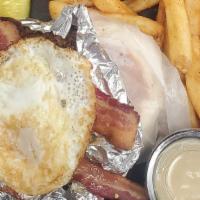 Brunch Burger · A juicy burger towering with crispy bacon, American cheese, smashed tater tots and a fried e...
