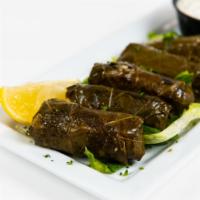 Dolmades · Stuffed grape leaves with rice and beef served with tzatziki.