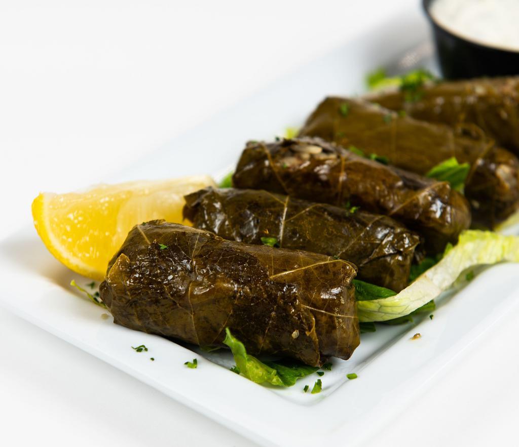 Dolmades · Stuffed grape leaves with rice and beef served with tzatziki.