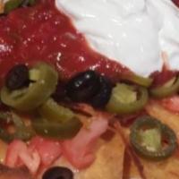 Nachos · Tortilla chips, salsa, melted cheddar, jalapenos, sour cream, black olives, and chopped toma...