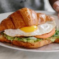 Croissant Breakfast Sandwich · Egg your style, Vermont cheddar, sliced tomato, avocado, and baby arugula on housemade crois...