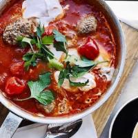 Lamb Meatball & Labneh Shakshuka · Tomato and bell pepper sauce, eggs, lamb meatballs, and peppadew peppers topped with spicy l...