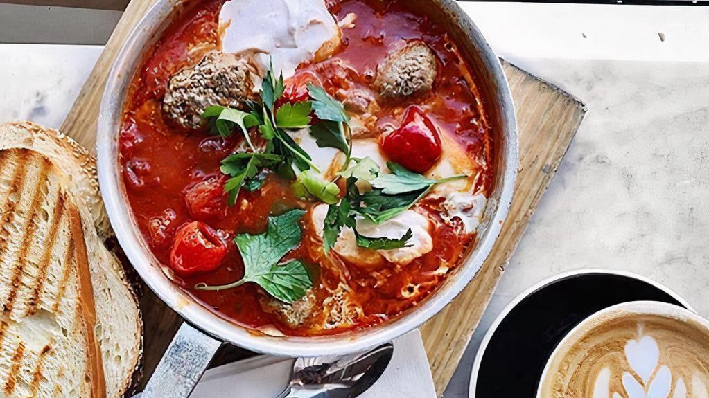 Lamb Meatball & Labneh Shakshuka · Tomato and bell pepper sauce, eggs, lamb meatballs, and peppadew peppers topped with spicy labneh and parsley. Served with housemade challah bread.. Contains: Wheat, Dairy, Egg