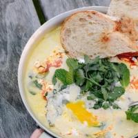 Corn & Spinach Shakshuka · Corn sauce, baby spinach, and eggs topped with Campari tomatoes, feta cheese, cilantro relis...
