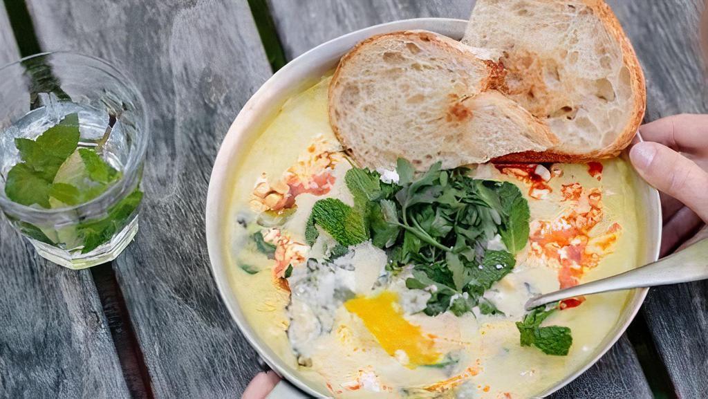 Corn & Spinach Shakshuka · Corn sauce, baby spinach, and eggs topped with Campari tomatoes, feta cheese, cilantro relish, Aleppo chili oil, red onion, and parsley. Served with housemade sourdough.. Contains: Wheat, Dairy, Egg