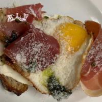 Prosciutto & Fried Egg Tartine · Prosciutto, housemade pesto, sunny-side . up egg, grated parmesan on a whipped goat and rico...