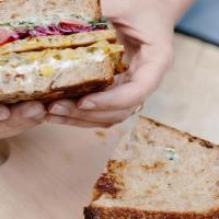 Corn Latke Sandwich · Corn latke, pickled red cabbage, tomato, red onion, and parsley served over toasted multigra...