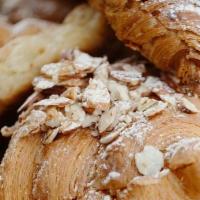 Almond Croissant · Filled with housemade almond cream,, topped with almonds, and dusted with powdered sugar.. C...