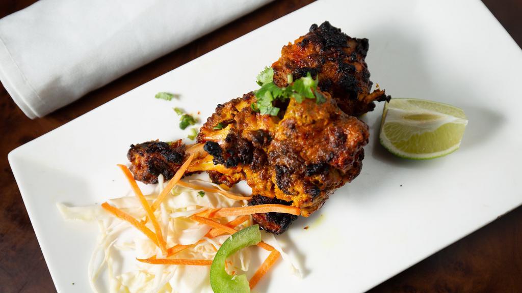 Tangdi Kebab · Chicken drumsticks generously marinated with aromatic spices and char-grilled to perfection. Served with grated salad and mint chutney.