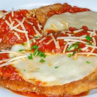 Veal Parmigiana · Breaded cutlet topped with fresh tomato sauce & baked with mozzarella cheese served with sid...