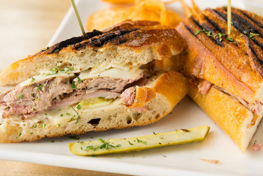 Cubano · Smoked pulled pork, Virginia ham, Swiss cheese, dill pickles and mustard sauce pressed on a  ciabatta bread.