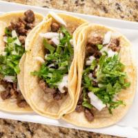 Carne Asada Tacos · Grilled steak with roasted peppers and grilled onions, cilantro, cucumber and tomatillo sauc...