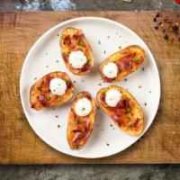 Posh Potato Skins · Baked potato skins filled with cheddar cheese, bacon, scallions, and topped with sour cream.