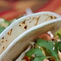 Crispy Fish Soft Tacos · Two soft tacos filled with crispy fish, slaw, & drizzled with Yum Yum sauce.  Served with a ...