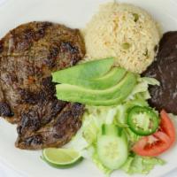 Carne Asada · Grilled steak. Served with rice, refried beans, avocado, salad, and flower tortillas.