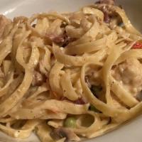 Fettuccine Carbonara · Sauteed chicken or scallops, pancetta, peas, mushrooms and roma tomatoes in a Romano cheese ...