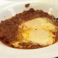 Classic Shakshuka · Gluten free. Two poached eggs in a tomato-based sauce with black and red peppers, paprika, g...