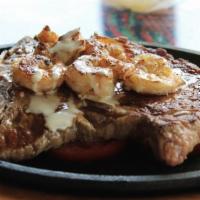 Steak Del Mar · Rib eye steak, shrimp, and tomatoes grilled and seasoned, topped with cheese sauce. Served w...