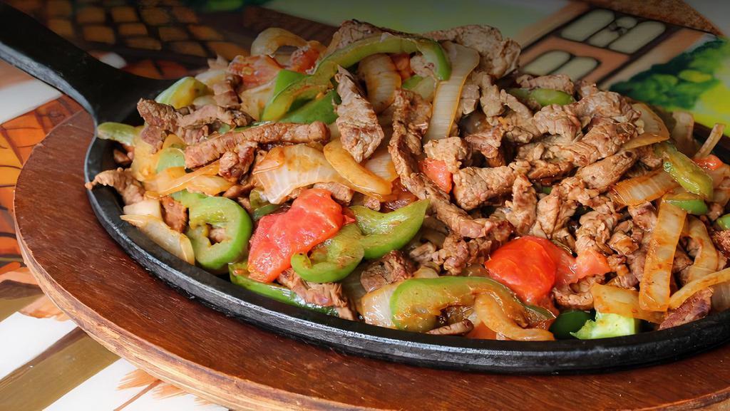 Fajitas Regular (Regular) · Tender sliced grilled steak or chicken on a sizzling hot skillet with bell peppers, onions, and tomato. Served with Spanish rice, refried beans, guacamole salad and flour tortillas.