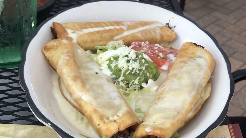 Chicken & Cheese Flautas · Three flour tortillas rolled and filled with marinated chicken, deep fried and then covered with cheese sauce. Topped with lettuce, sour cream, cheese, tomato, guacamole. Served with Spanish rice and refried beans.