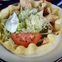 Taco Salad · A crispy flour tortilla bowl filled with refried beans, your choice of marinated chicken or ...