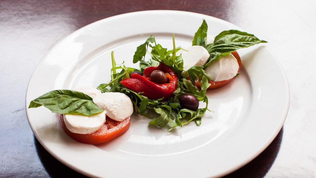 Caprese Salad · Fresh Mozzarella, fresh ripe tomatoes and roasted red peppers drizzled with balsamic vinaigrette on a bed of crisp spring mix.