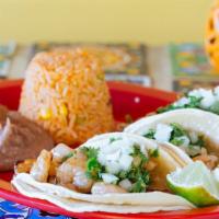 Shrimp Tacos · Three shrimp tacos topped with onions and cilantro. Serve with rice and beans. Your choice o...
