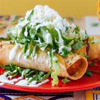Tacos Dorados · Three crispy corn tortillas wrapped with potatoes and marinated chicken. Topped with lettuce...