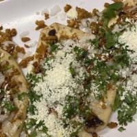 Tlacoyos · Diamond shaped tortilla stuffed with beans and topped with onions, cilantro & queso fresco.