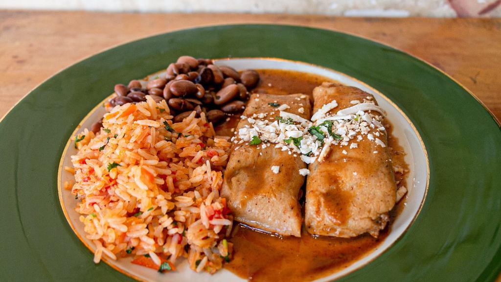 Pork Tamale Dinner · Gluten Free. Two tamales filled with spicy seasoned pork accompanied by Spanish rice and pinto beans.