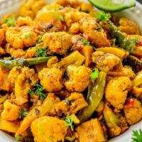 Aloo Gobi (V) · Vegan, gluten free. Steamed cauliflower with potatoes and tomatoes, flavored with Indian her...