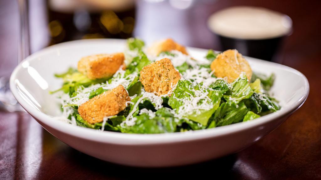 Chicken Caesar Salad · A juicy, sliced grilled chicken breast tops fresh Romaine lettuce accented with crunchy croûtons, freshly shredded Parmesan cheese, and creamy Caesar dressing.