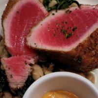 Tuna Impanato · Breaded seared tuna served rare with sautéed spinach and cannellini bens with roasted pepper...