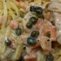 Chicken Toscanus · Tender chicken sautéed in olive with garlic, tomatoes and capers and tossed with linguini an...