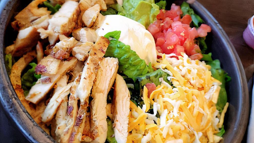Chicken Avocado Salad  · Grilled chicken breast, romaine lettuce, grilled corn, avocado,
tomatoes and  shredded cheese.  Served with cilantro
lime dressing and a lime wedge