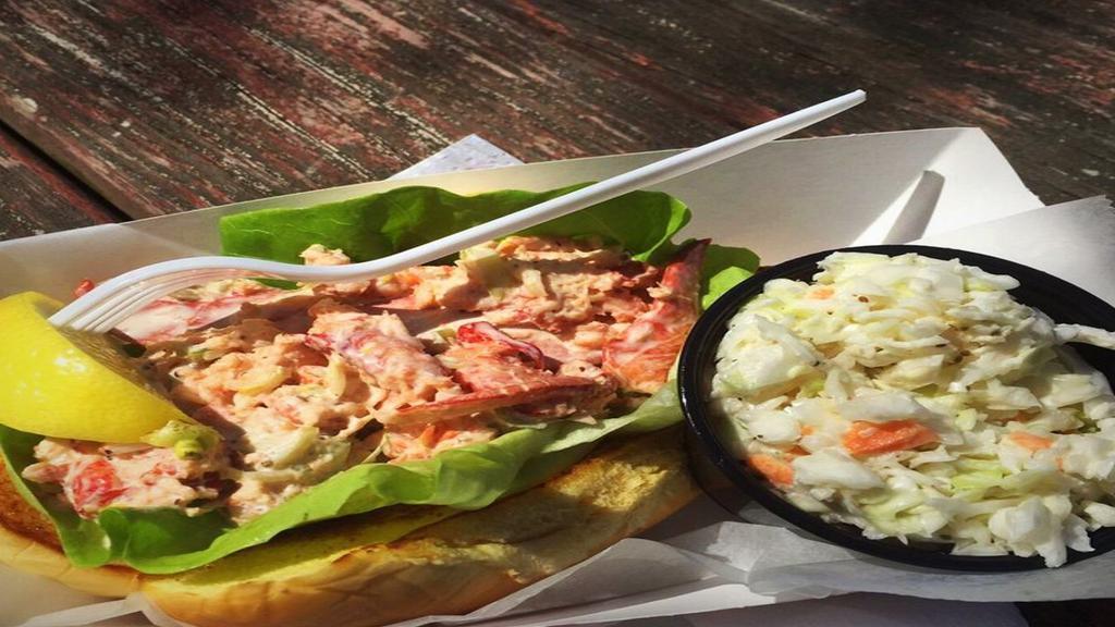 Lobster Roll Sandwich · Whole Maine lobster meat lightly tossed in a perfectly seasoned dressing, nestled in a bed of lettuce on a warm grilled New England style bun (That’s where the “MAGIC“ happens!), served with our homemade coleslaw.