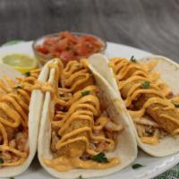 Fish Taco · A wonderful, potato encrusted cod nestled in soft flour tortillas, topped with taco rice, pi...