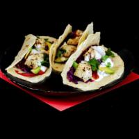 Baja Shrimp Tacos · Three crispy battered shrimp with cabbage slaw and crema.