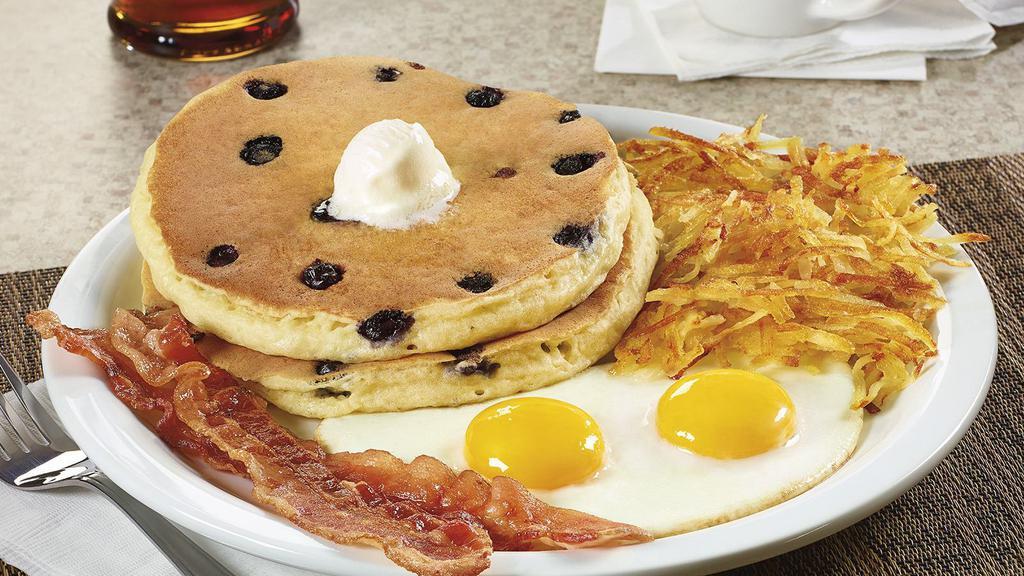 Blueberry Pancake Breakfast. · Juicy blueberries cooked inside two buttermilk pancakes. Served with two eggs and hash browns, plus your choice of two bacon strips or two sausage links.