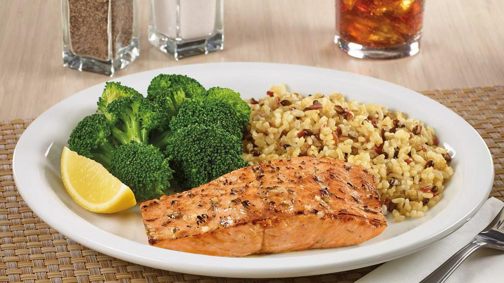 Wild Alaskan Salmon · A grilled Alaskan salmon fillet with a delicious blend of garlic and herbs. Served with two sides and dinner bread.
